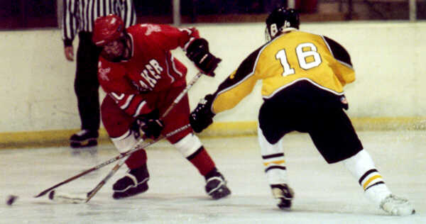 Milton Carter pokes the puck away from a Raider.