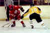 Milton Carter pokes the puck away from a Raider.
