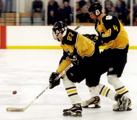 Andrew West and Milton Carter converge on a loose puck.