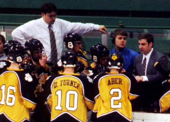 The coaching staff talks with the Tigers during a timeout.