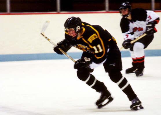 A Kent Rough Rider trails Joe Ross down the ice.